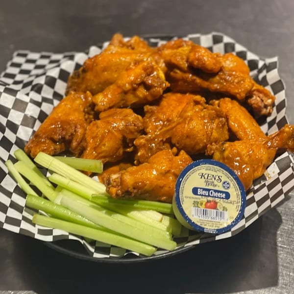 Jack's Slice buffalo wings with celery sticks and a cup of bleu cheese dressing.